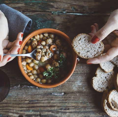 woman eating mediterranean soup with bread, close up