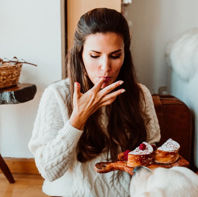 woman eating sweet food while sitting at home