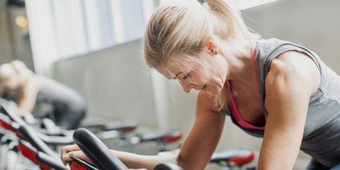 Woman exercising on stationary bicycle in gym