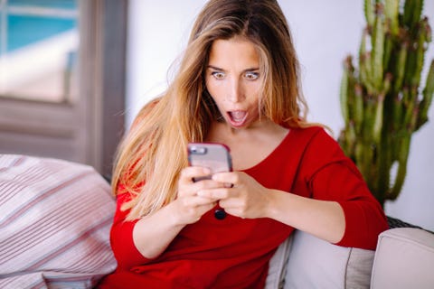 Woman feeling big surprise checking phone