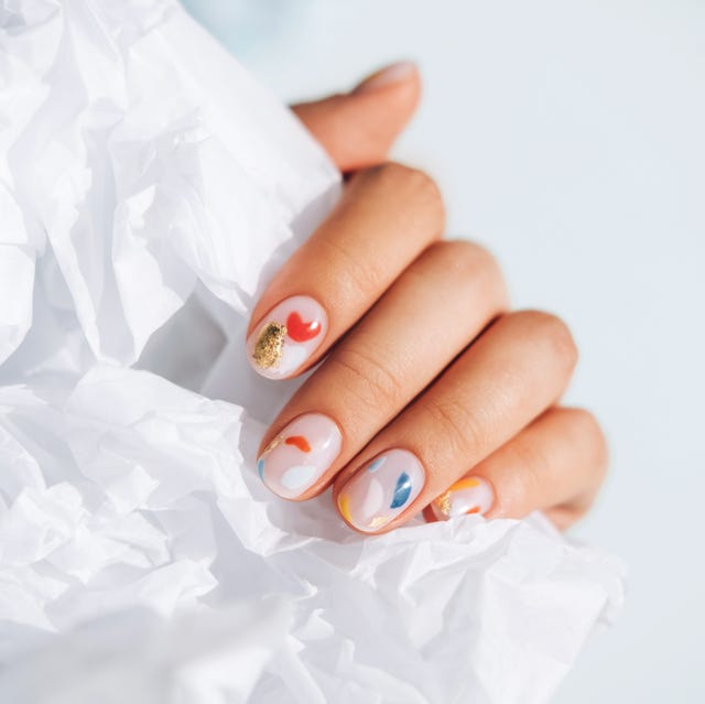 Woman hand with beautiful colorful manicure is holding white paper. Trendy bright colors of the year woman hand with beautiful colorful manicure is holding white paper trendy bright colors of the year