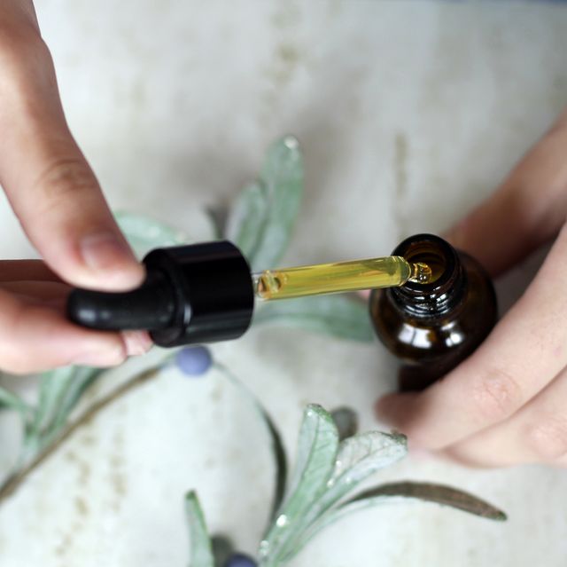 woman hands holding pipette of essential oil