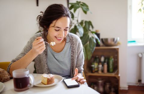 woman having breakfast and using phone