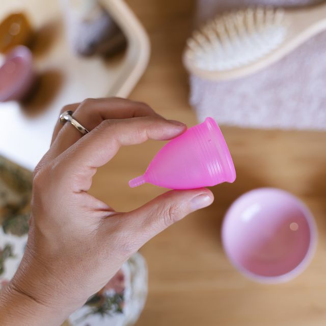woman holding a menstrual cup