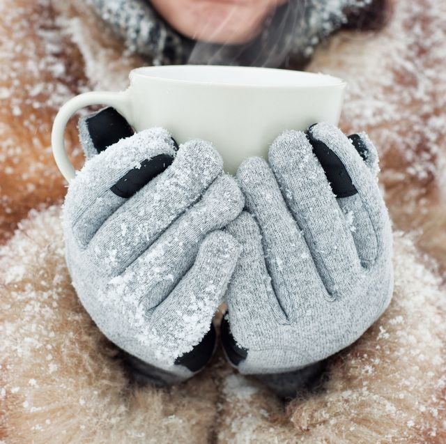 woman holding a mug wearing winter gloves