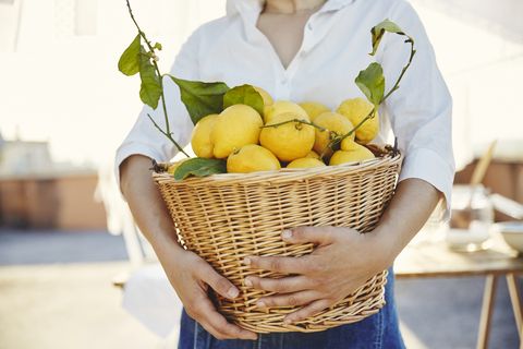 Woman holding basket full of lemons