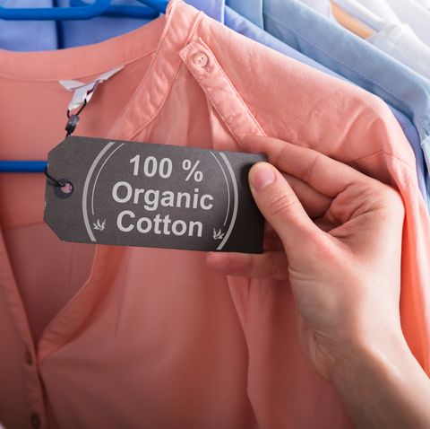 Woman Holding Label Showing 100 Percent Organic Cotton