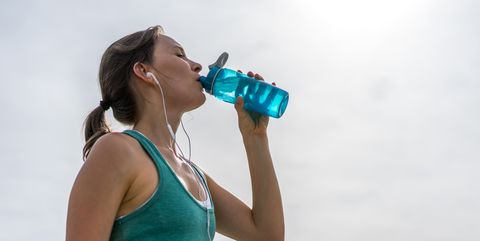 Woman hydrating after running outdoors