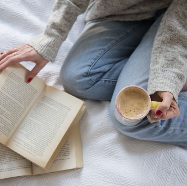 mujer leyendo en la cama con café