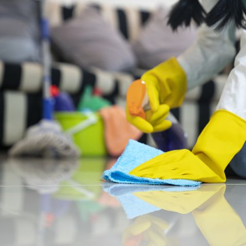 Woman in protective gloves cleaning her house