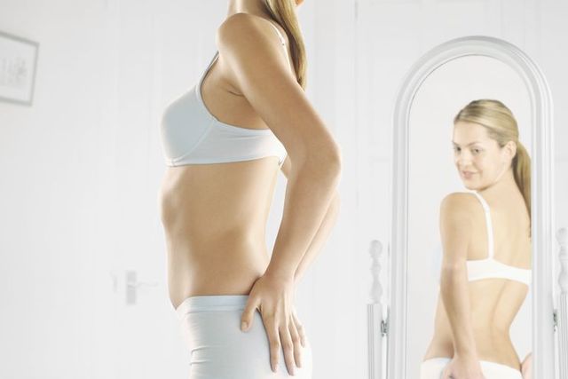 Woman in Underwear Looking at Her Reflection in a Mirror