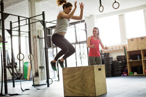 Mulher pulando na caixa com instrutor de fitness Mulher pulando na caixa com instrutor de fitness