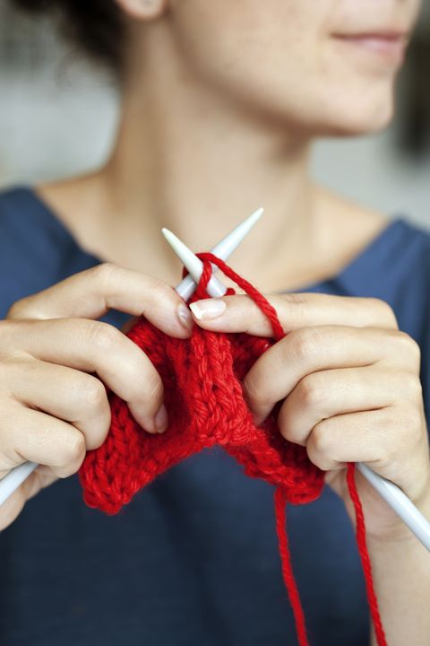 woman knitting with red yarn