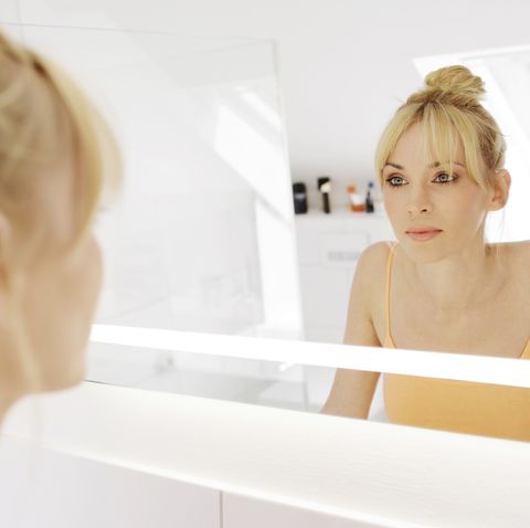 woman looking at her mirror image in the bathroom