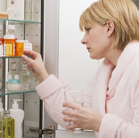Woman looking in medicine cabinet
