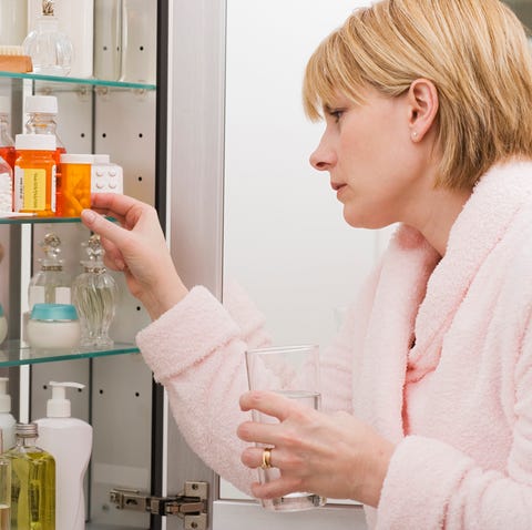 Woman looking in medicine cabinet