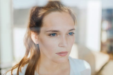 woman looking serious behind a window