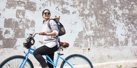 Woman on blue bike with small dog