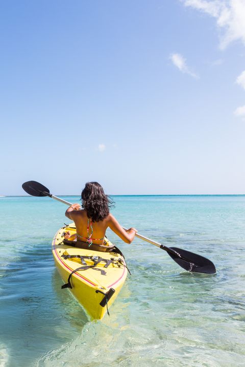 Woman on kayak near beach in a tropical island, Fiji