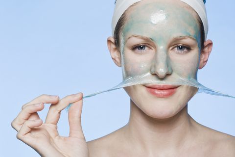 A woman peeling a face mask off her face