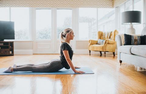 woman performing cobra stretch on a yoga mat