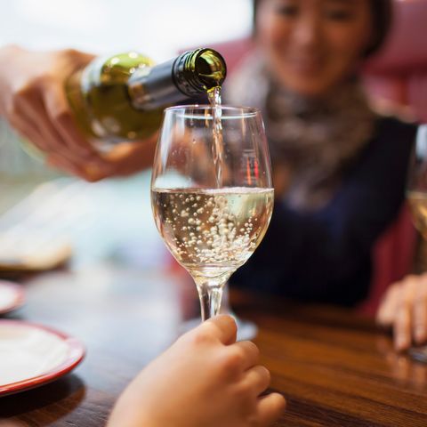 woman pouring white wine, close up