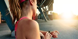 Woman programming her smartwatch before going jogging to track performance