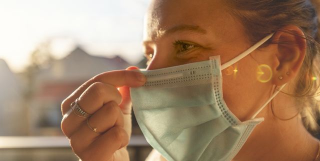 woman putting on a surgical face mask