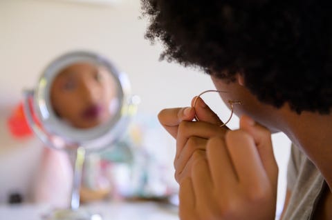Woman putting on hoop earring how to clean earrings