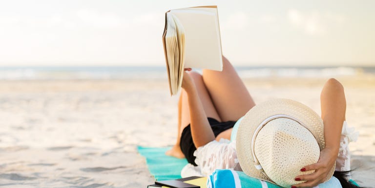 Woman reading book at beach