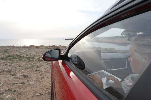 Woman relaxes in car near edge of sea woman relaxes in car near edge of sea