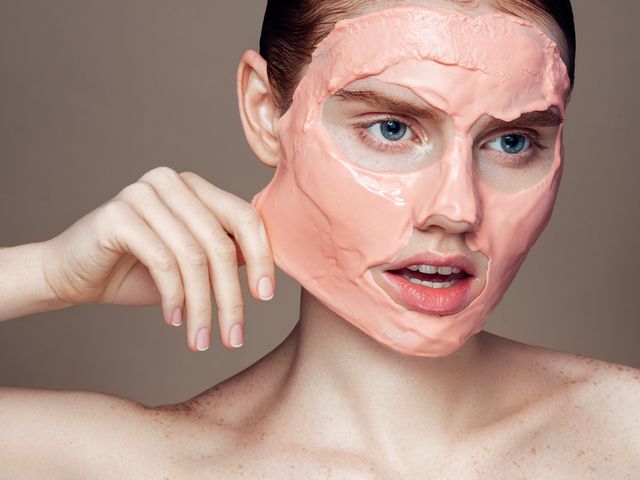 woman removing mask from face