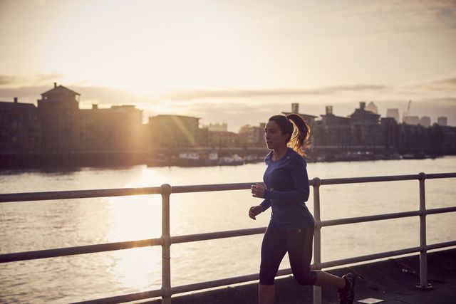a woman running alongside the river thames in london