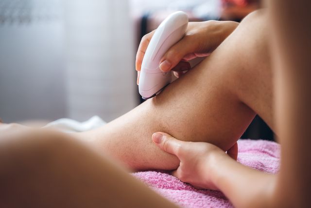 woman shaving legs with depilator