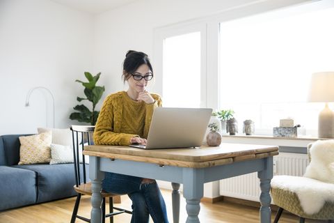 Woman sitting at table, using laptop