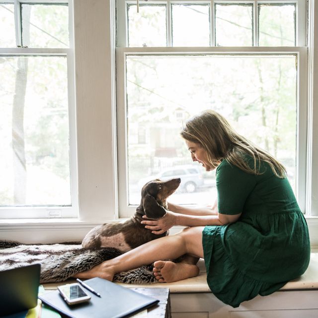 woman sitting in window with dog