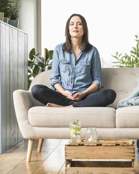 woman sitting on the couch at home with closed eyes