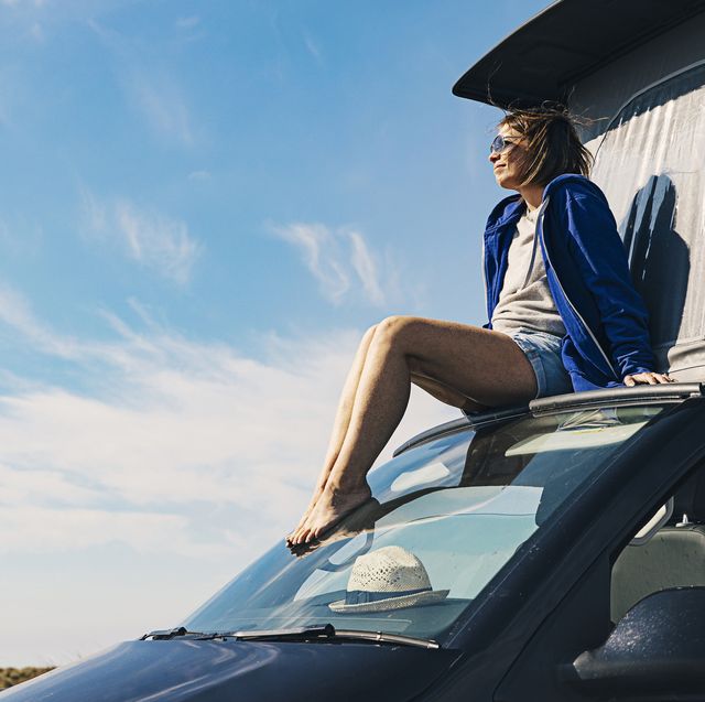 woman sitting on the roof on a campervan