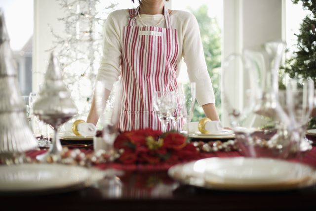 woman standing by table decorated for christmas