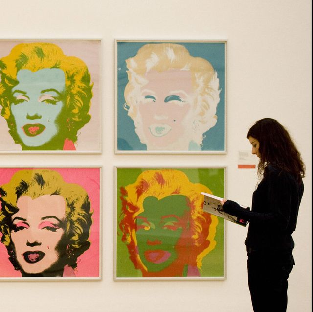 a woman stands beside the work "marilyn