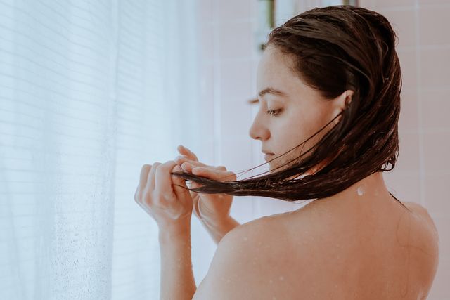 woman taking a shower and washing her hair at home