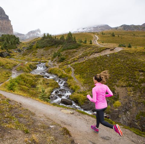 A woman trail running in the mountains.
