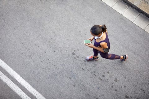 woman using mobile phone while walking on street