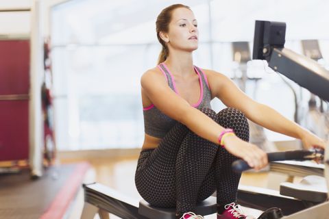 Woman using rowing machine at gym