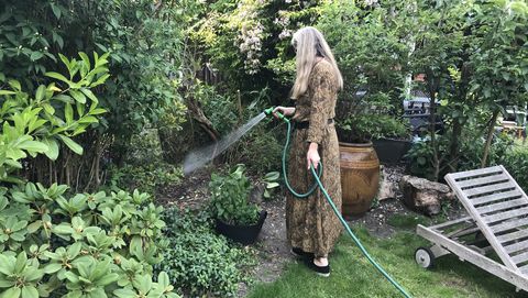 vrouw geeft de tuin water