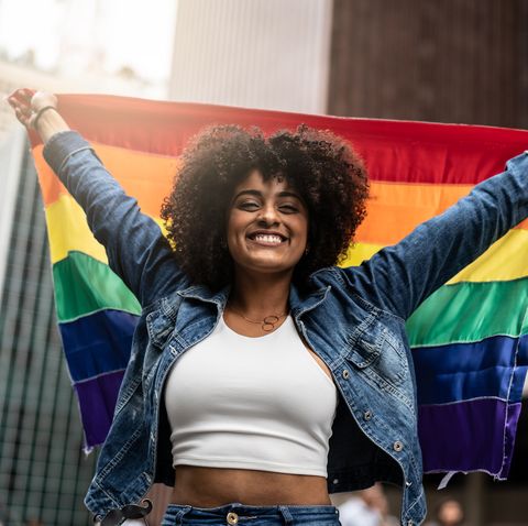 woman waving rainbow flag at gay parade