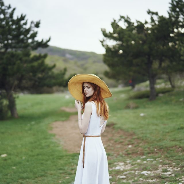 woman wearing sun hat standing in field