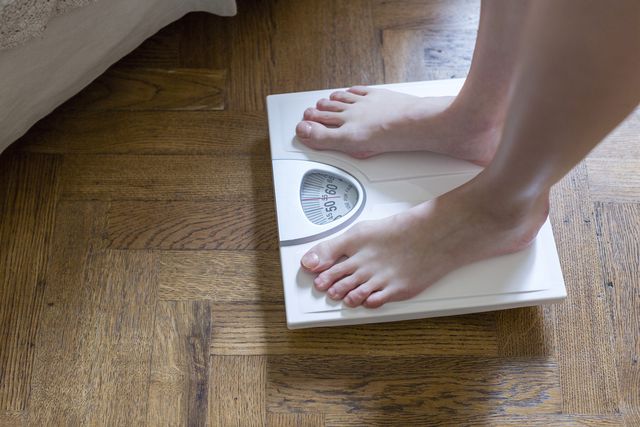 womans feet standing on bathroom scales