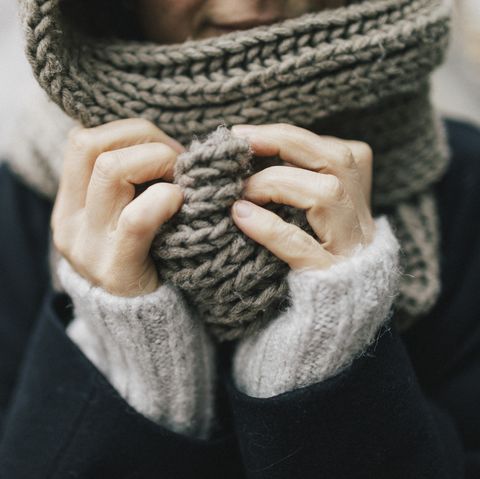 woman's hand holding knitted scarf, close up