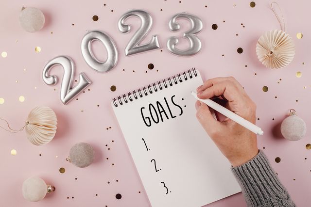 woman's hand writing goals 2023 for new year